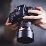 person holding Canon DSLR camera