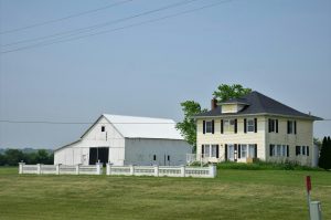 a large white house sitting on top of a lush green field